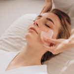 Woman in salon making beauty treatment with gua sha stone