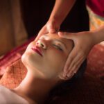Masseur doing massage on Asian woman body in the spa salon