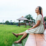 woman sitting and relax on Wood bridge with their legs hanging down